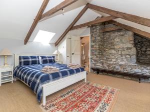a bedroom with a bed and a stone wall at Wdig Cottage - Qc1264 in St. Davids