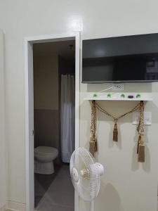 uma casa de banho branca com uma ventoinha e um WC. em Holland Park Condominium Southwoods Biñan Laguna em Jalang