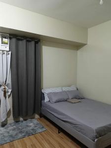 um quarto com uma cama com uma cortina preta em Holland Park Condominium Southwoods Biñan Laguna em Jalang