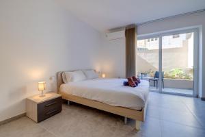a bedroom with a bed and a large window at Modern Maisonette in a Central Location in San Ġwann +23 photos