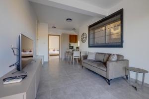 a living room with a couch and a tv at Modern Maisonette in a Central Location in San Ġwann