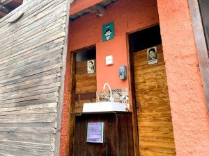 un bâtiment avec une porte en bois et des panneaux. dans l'établissement Hostel Vento Leste, à Bombinhas