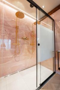 a glass walled shower in a room with aitatingermottermott at Boetiekhotel Faan - NIEUW! in Ballum