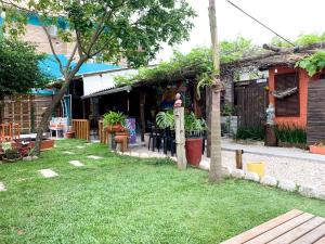 a backyard of a house with a grass yard at Hostel Vento Leste in Bombinhas