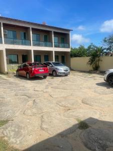 dois carros estacionados em frente a um edifício em Pousada Bon Vivant em Cabo Frio