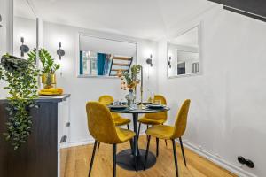 a dining room with a table and yellow chairs at Tempus Te Premium Duo Lofts Tartu - private cinema, gym and terrace in Tartu