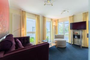 a living room with a couch and a tv at Villa Strandperle, App 04 - nur 20m zum Strand, TOPLAGE in Binz +12 photos