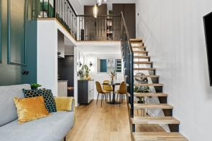 a staircase in a living room with a blue couch at Tempus Te Premium Duo Lofts Tartu - private cinema, gym and terrace in Tartu