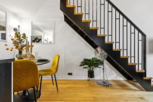 a dining room with a table and a staircase at Tempus Te Premium Duo Lofts Tartu - private cinema, gym and terrace in Tartu