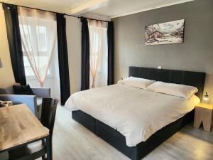 a bedroom with a large bed and a table at Auberge de l’Union in Lens