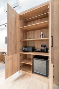 Cette chambre dispose de murs en bois, d'étagères et d'une télévision. dans l'établissement ERMOU 40 SUITES, à Athènes