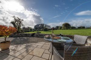 a patio with a table with a bowl of food on it at Countryside cottage in tranquil surroundings in Broadwoodwidger