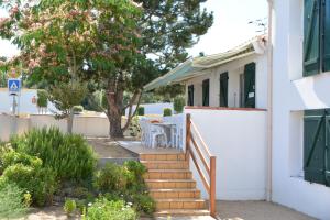 une maison blanche avec un escalier menant à une cour dans l'établissement Les Floralies, à La Tranche-sur-Mer