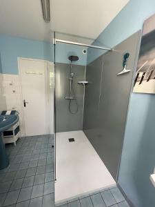 La salle de bains est pourvue d'une douche avec une porte en verre. dans l'établissement Les Floralies, à La Tranche-sur-Mer