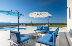 Un patio con sillas azules y una sombrilla y una piscina. en Villa Panorama, en Buzet 47 fotos más