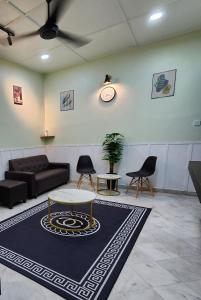 uma sala de estar com um sofá, uma mesa e cadeiras em Sun Star Home by Ipoh Maju Stay em Ipoh