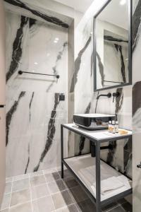 une salle de bain avec un lavabo et une douche dans l'établissement ERMOU 40 SUITES, à Athènes 104 autres photos