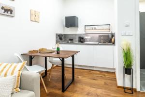 a living room with a table and a kitchen at Horský apartmán v resortu se službami a wellness in Vrchlabí