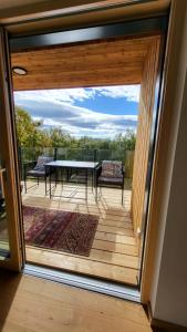 een glazen schuifdeur naar een terras met een tafel en stoelen bij Haus am Hochwechsel in Breitenbrunn