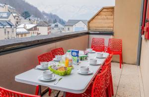 Biały stół i krzesła na balkonie w obiekcie Appartement Le Bois de Marie w mieście Barèges
