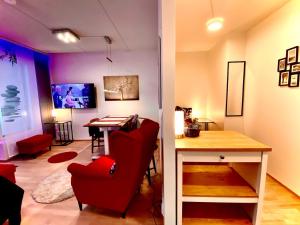 ein Wohnzimmer mit einem roten Stuhl und einem Tisch in der Unterkunft To LuxStudio SAVUsuite From Helsinki Airport 6 min, to City 27min, FreeParking in Kivistö in Vantaa