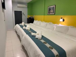 a large bed with white pillows in a room at R Hotel Langkawi in Kuah