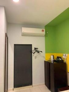 a room with a heater and a green wall at R Hotel Langkawi in Kuah