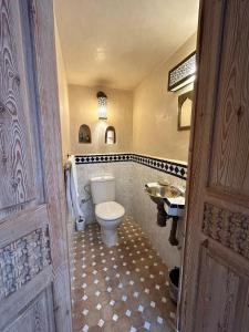 a bathroom with a toilet and a sink at Beau riad en médina, lumineux et avec terrasse privée sur mer in Essaouira