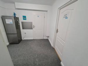 um quarto vazio com um frigorífico e uma porta em Fantastic - NW30 Room C em Varsóvia