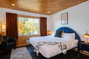 a bedroom with a large bed and a window at Town House Lodge in Lake Placid