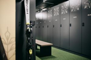 a row of lockers with a bench in a locker room at Almresort Sonnenalpe by ALPS RESORTS in Sonnenalpe Nassfeld