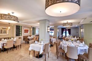 a restaurant with white tables and chairs and chandeliers at Renata Boutique Hotel Sisli in Istanbul