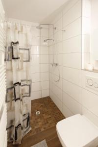 a white bathroom with a shower with a toilet at Central apartment with Terrace and a free parking in Duisburg