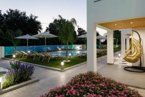 a resort with a pool with tables and chairs and umbrellas at Coconut Palm Paradise in Gállos