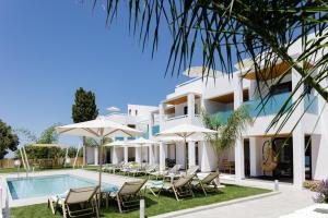 a villa with a swimming pool and chairs at Coconut Palm Paradise in Gállos