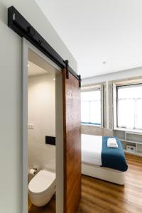 een badkamer met een bed en een toilet in een kamer bij Maria da Sé Historic House in Porto