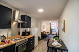 a kitchen with black cabinets and a table with a dining room at Cosy and Homey 1br flat in Sunderland Centre - Flat 2 in Sunderland