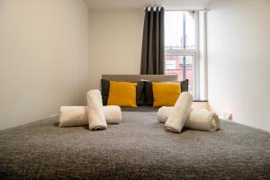 um quarto com uma cama com almofadas e uma janela em Cosy and Homey 1br flat in Sunderland Centre - Flat 2 em Sunderland
