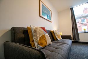 uma sala de estar com um sofá com almofadas em Cosy and Homey 1br flat in Sunderland Centre - Flat 2 em Sunderland