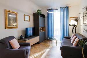 a living room with two couches and a tv at EASY FLAT MANIN in Turin