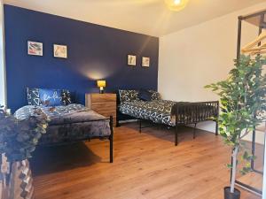 una camera con due letti e una parete blu di Hereford House - Welcome Short Stays a Derby