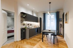 a kitchen with a table and a small table and chairs at EASY FLAT MANIN in Turin