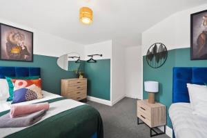 a bedroom with two beds and a blue wall at Boutique Nottingham Abode - Sleeps 6 in Nottingham