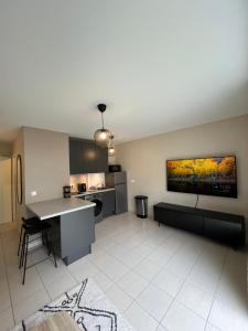 a living room with a kitchen with a couch and a table at Charmant studio en résidence avec parking in Bussy-Saint-Georges