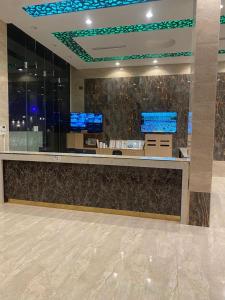 a lobby with a counter with two monitors on it at شاليهات ركـــام Recam For Holiday in Qarār +37 photos