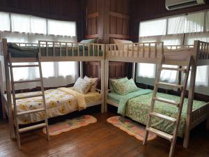 two bunk beds in a room with windows at Yor Song Hostel in Pai