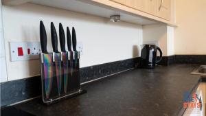 a kitchen with knives hanging on a wall at OnSiteStays - 2 Bedroom Apartment with Ensuite, Free Parking & Wi-Fi in Gravesend