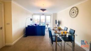 a dining room and living room with a table and chairs at OnSiteStays - 2 Bedroom Apartment with Ensuite, Free Parking & Wi-Fi in Gravesend