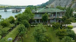 una casa junto al agua con árboles y un río en Buna Park Hotel, en Shkodër