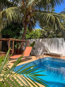 a swimming pool with a chair and a palm tree at Francesca Guest House in Dakar